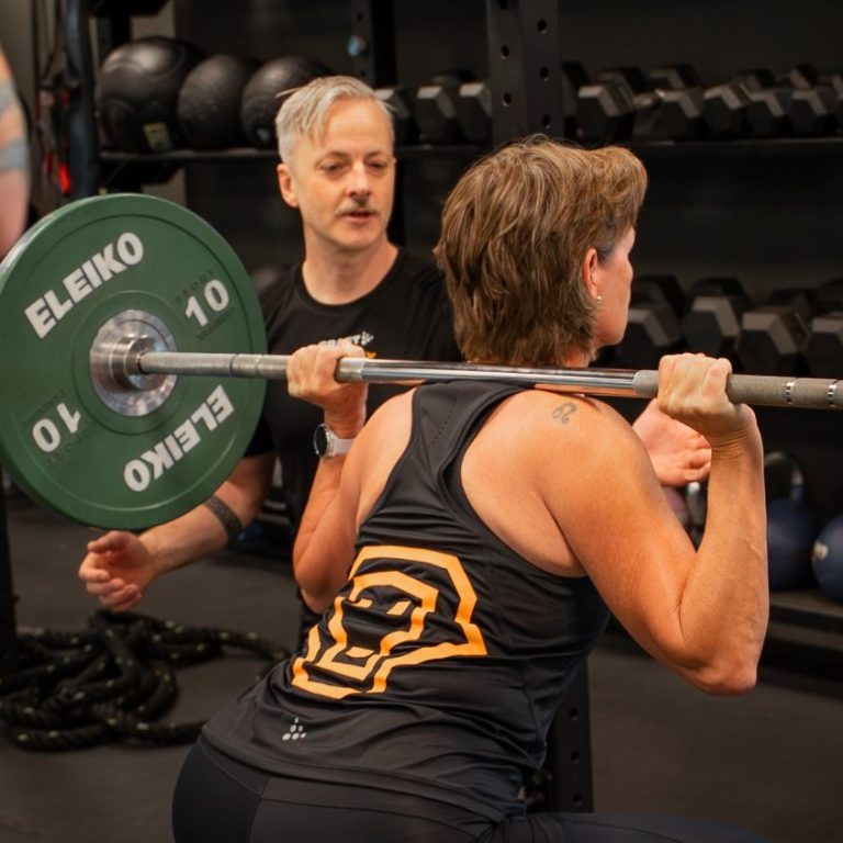 PT Göteborg Personlig tränare hjälper klient med styrketräning på gym i Göteborg