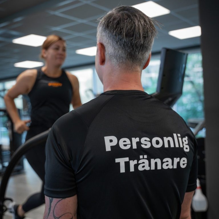 PT Göteborg Personlig tränare hjälper klient med styrketräning på gym i Göteborg