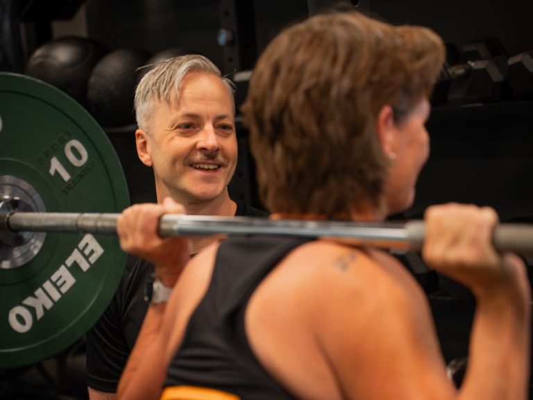 PT Göteborg Personlig tränare hjälper klient med styrketräning på gym i Göteborg